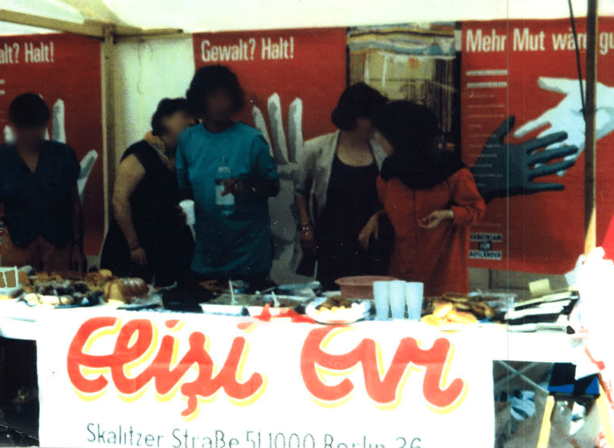 Personen hinter einem Tisch mit Essen