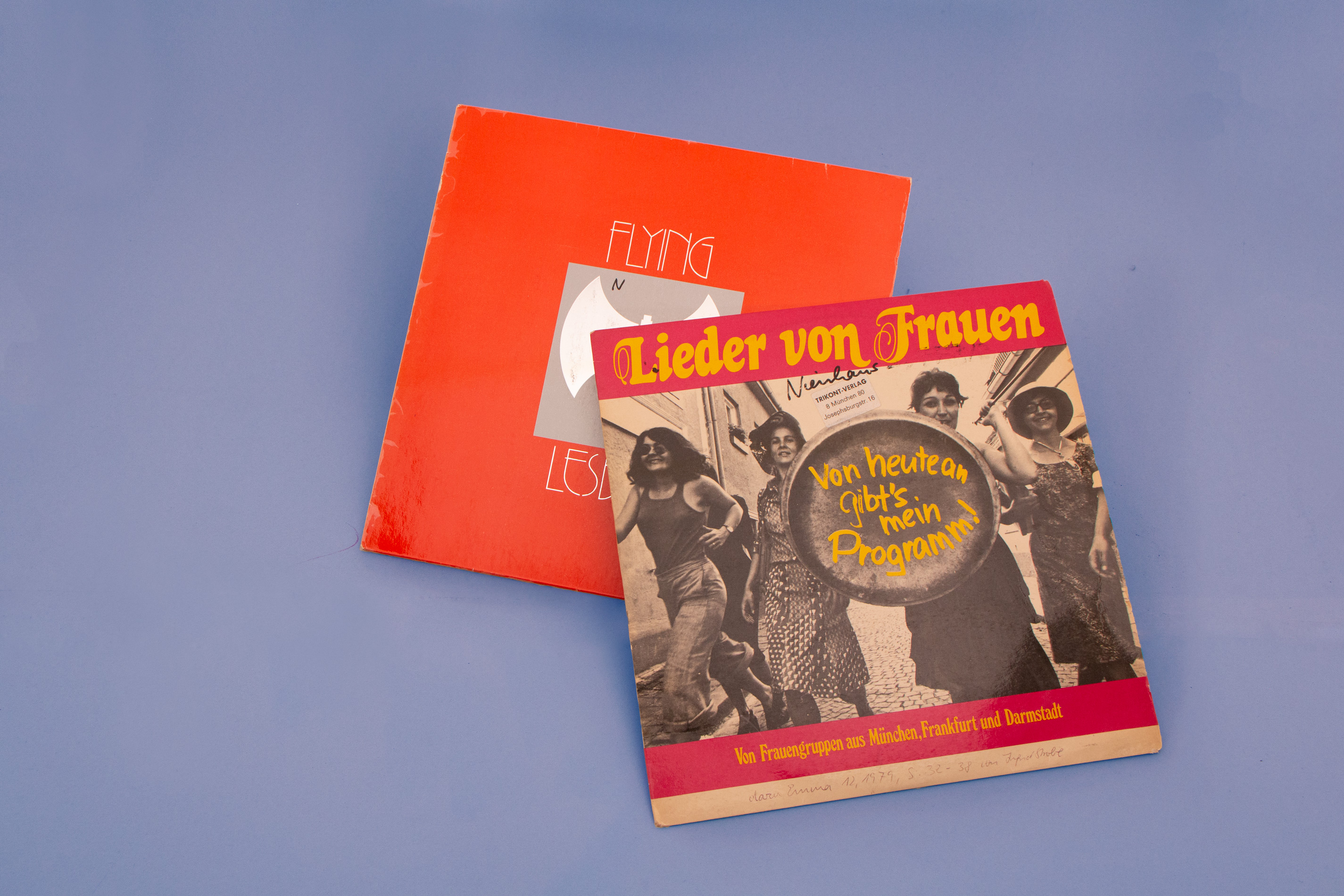 Schallplatte mit dem Foto der Frauenmusikgrupppe / rote Schallplatte mit Grafik einer Doppelaxt