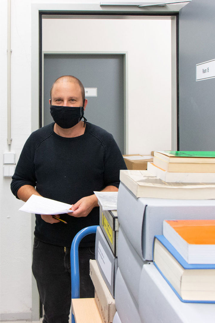 Roman Klarfeld bei der Arbeit neben einem Archivwagen